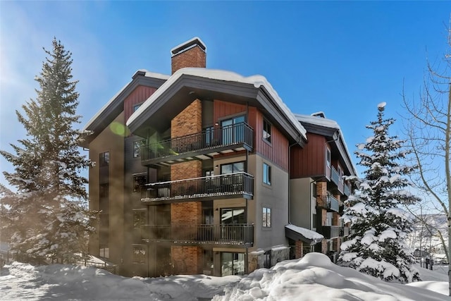 snow covered property featuring a chimney