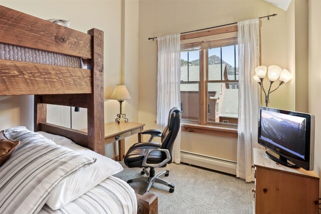 bedroom with light carpet and baseboard heating