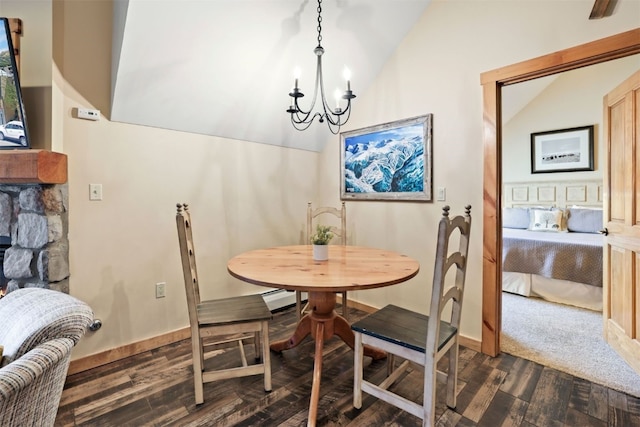 dining area with dark wood-type flooring, lofted ceiling, a chandelier, and a baseboard heating unit