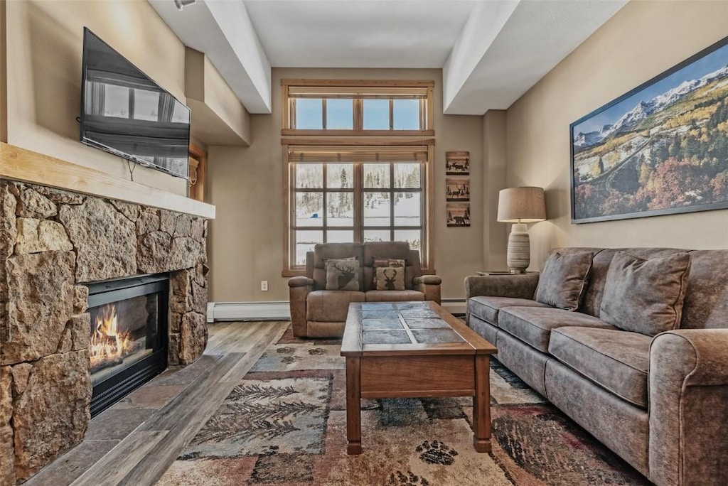 living room with hardwood / wood-style flooring, a fireplace, and baseboard heating