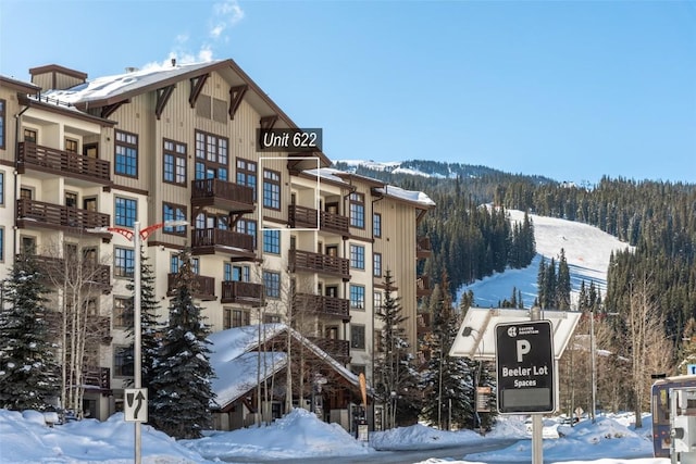 snow covered building featuring a mountain view