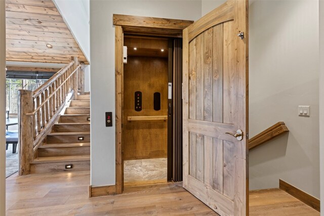 staircase with hardwood / wood-style flooring and elevator