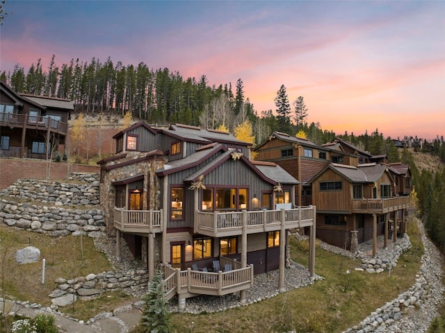 back house at dusk with a balcony