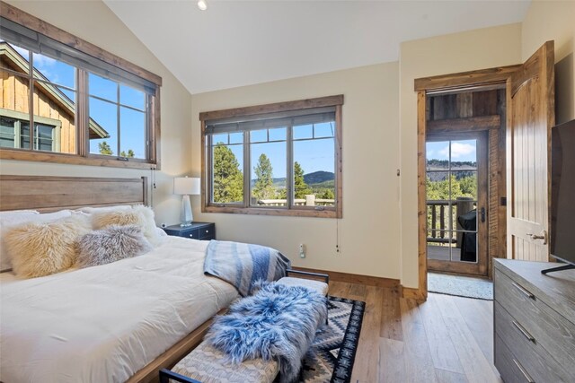 bedroom featuring lofted ceiling, access to outside, and light hardwood / wood-style flooring