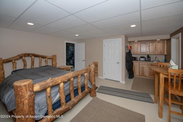 bedroom with a paneled ceiling and sink