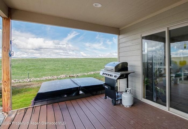 wooden deck featuring a rural view, grilling area, and a lawn