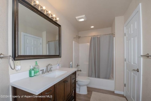 full bathroom with hardwood / wood-style floors, vanity, shower / bath combination with curtain, and toilet