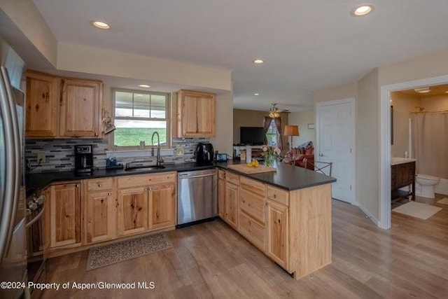 kitchen featuring light hardwood / wood-style floors, sink, kitchen peninsula, and stainless steel appliances