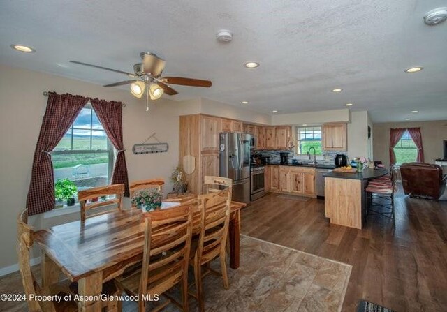 dining area with a textured ceiling, dark hardwood / wood-style floors, and ceiling fan