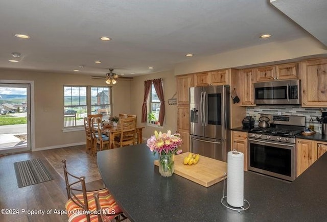 kitchen with ceiling fan, light brown cabinets, dark wood-type flooring, decorative backsplash, and appliances with stainless steel finishes