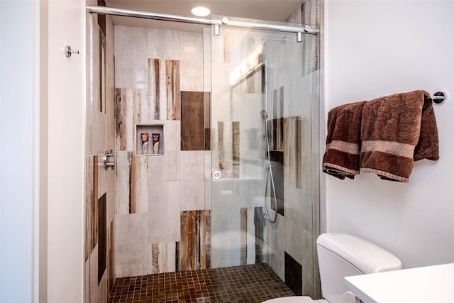 bathroom with toilet and a shower with shower door