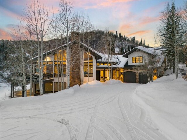 snow covered property featuring a mountain view and a garage