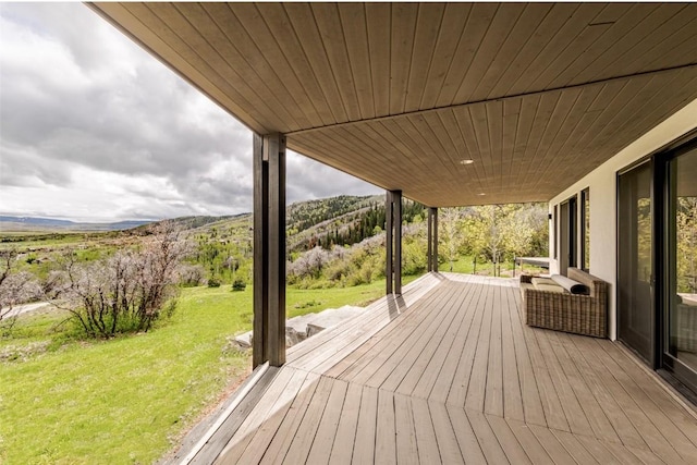 deck with a mountain view and a lawn