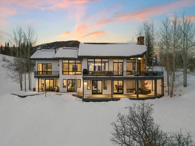 snow covered property featuring a mountain view and a garage