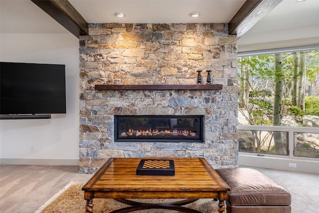 living room featuring carpet, a fireplace, and beamed ceiling