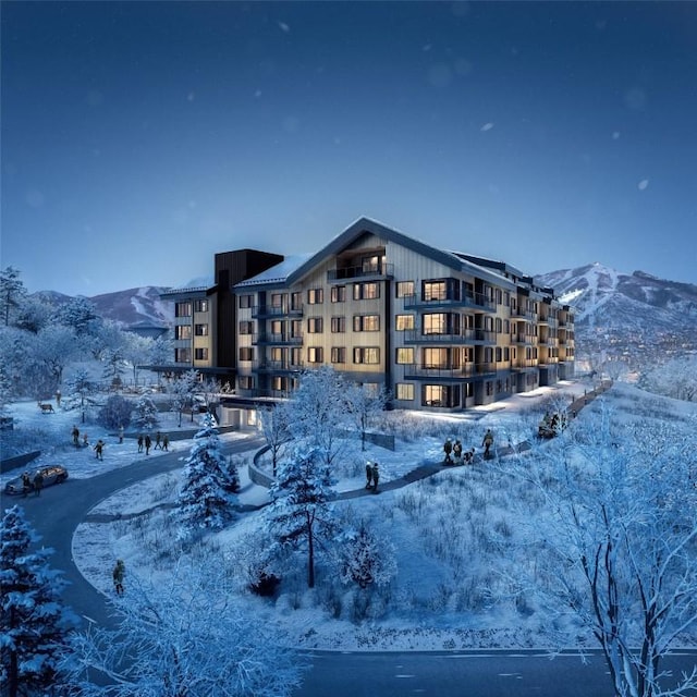 snow covered building featuring a mountain view