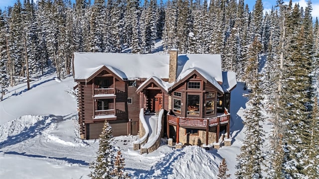 log home featuring log siding and a chimney