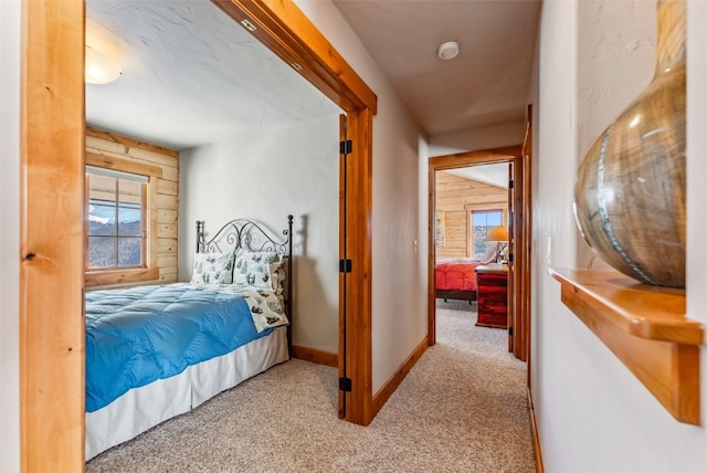 bedroom featuring wooden walls, baseboards, and carpet floors