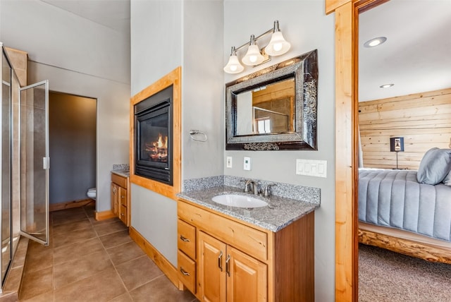 full bath featuring tile patterned flooring, toilet, vanity, a stall shower, and ensuite bath