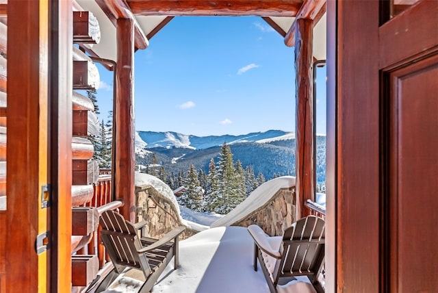 snow covered back of property with a mountain view