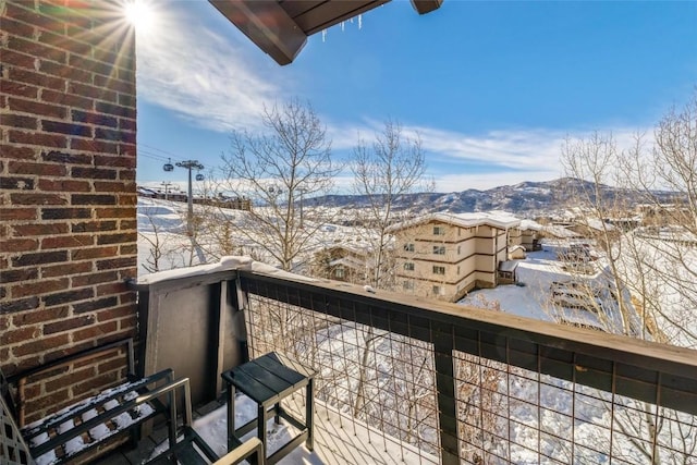 snow covered back of property with a mountain view