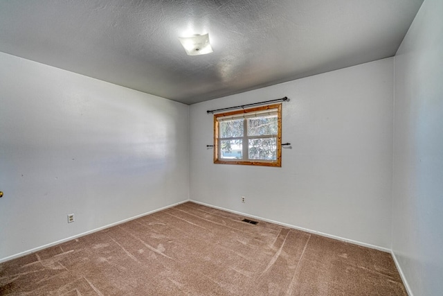 carpeted empty room with a textured ceiling