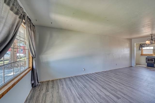 empty room featuring hardwood / wood-style flooring, a notable chandelier, and a wealth of natural light