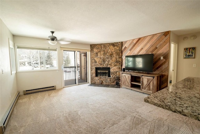 unfurnished living room featuring wood walls, a fireplace, ceiling fan, and a baseboard heating unit