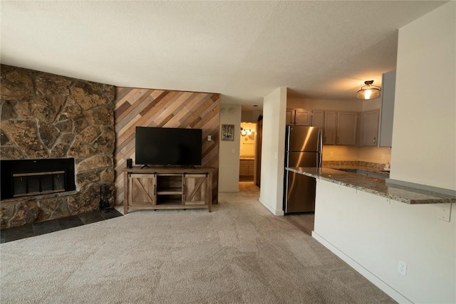 unfurnished living room featuring wooden walls, a fireplace, and dark carpet