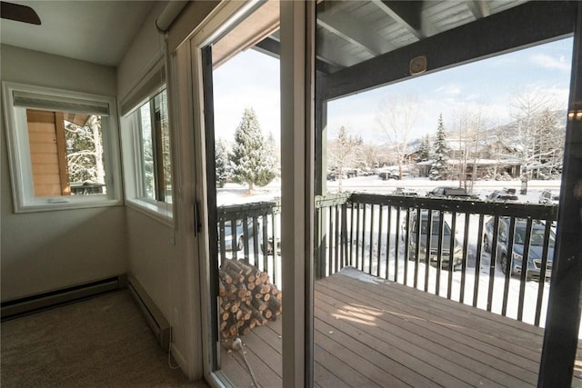 doorway to outside with ceiling fan and baseboard heating