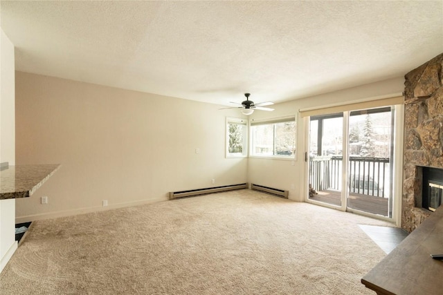 unfurnished living room with a stone fireplace, ceiling fan, a textured ceiling, baseboard heating, and light colored carpet