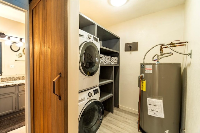 washroom featuring stacked washer and dryer, gas water heater, and light wood-type flooring