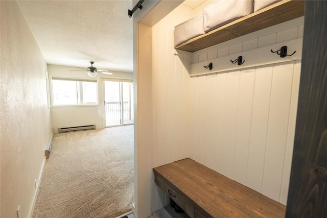 mudroom featuring carpet floors, baseboard heating, ceiling fan, and a barn door