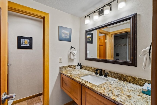 bathroom featuring tile patterned flooring, vanity, and a textured ceiling