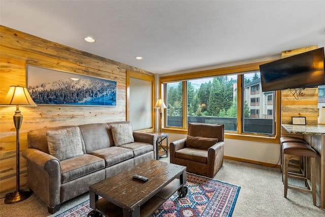 carpeted living room featuring wooden walls