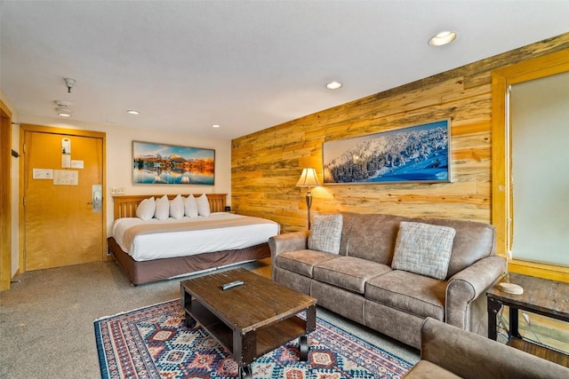 bedroom with wooden walls and carpet floors