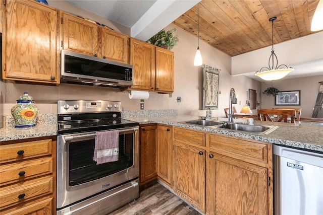 kitchen featuring sink, hanging light fixtures, appliances with stainless steel finishes, and dark wood-type flooring