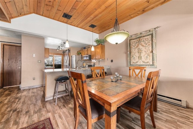 dining area featuring wooden ceiling, a baseboard radiator, and light wood-type flooring