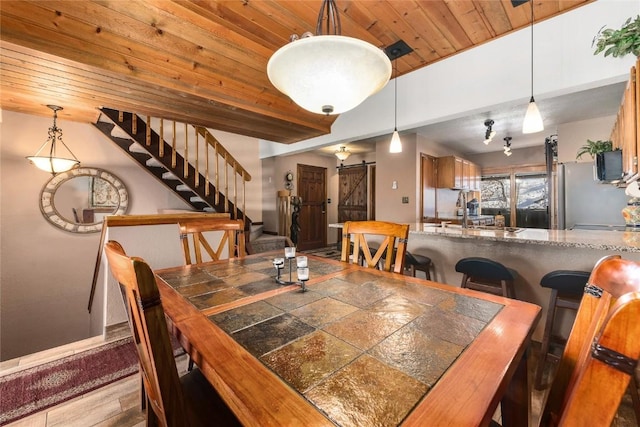 dining room with a barn door, sink, wood ceiling, and hardwood / wood-style flooring