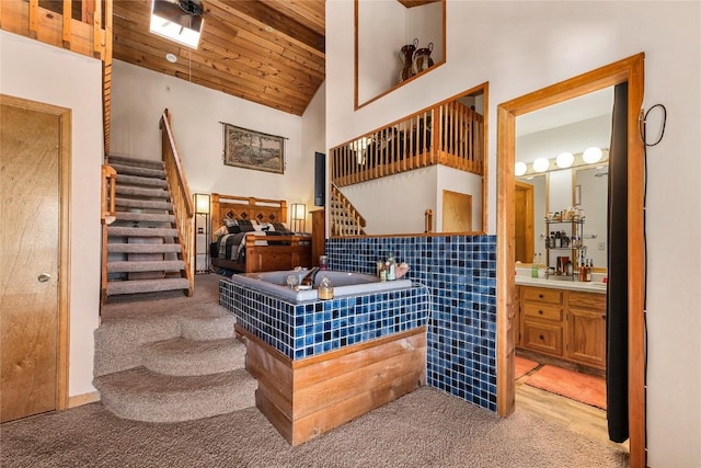 interior space featuring beam ceiling, carpet, wooden ceiling, and high vaulted ceiling