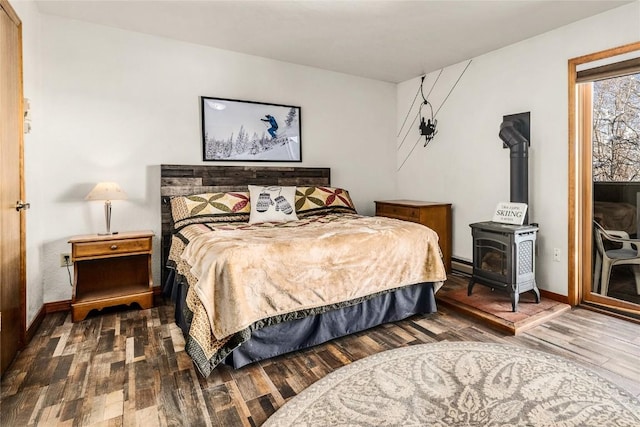 bedroom with dark hardwood / wood-style floors and a wood stove