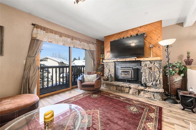 living room with a wood stove, wood walls, and hardwood / wood-style floors