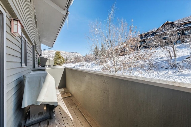 snow covered back of property featuring a mountain view