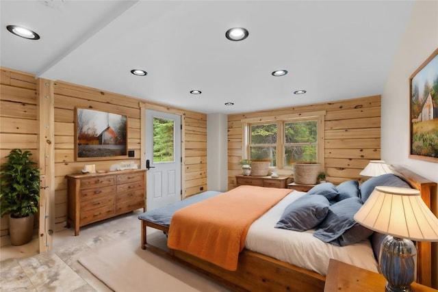 bedroom featuring wooden walls and multiple windows