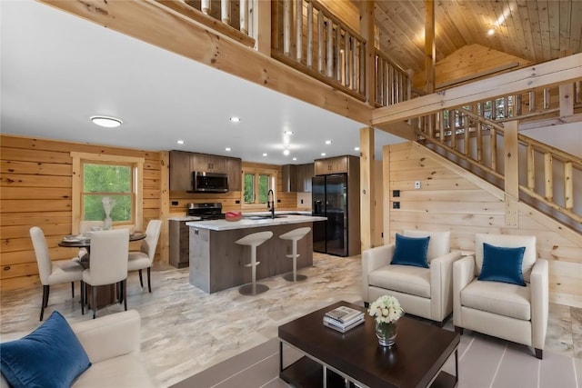 living room with wood walls, wood ceiling, sink, and vaulted ceiling