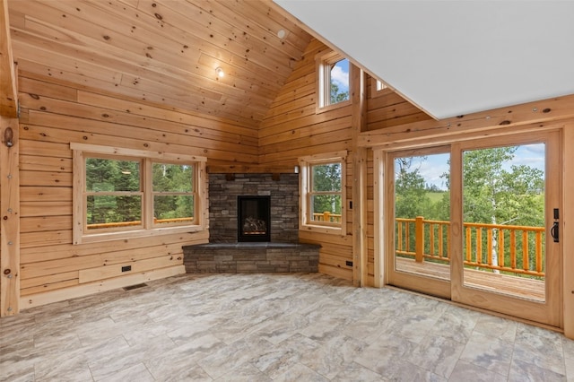 unfurnished living room with wood walls, wooden ceiling, a fireplace, and high vaulted ceiling