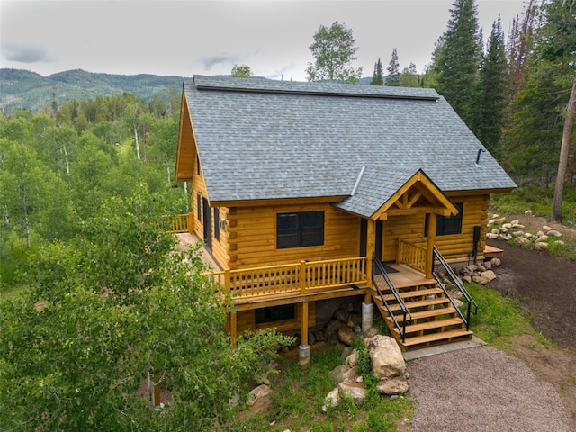 log home with a deck with mountain view