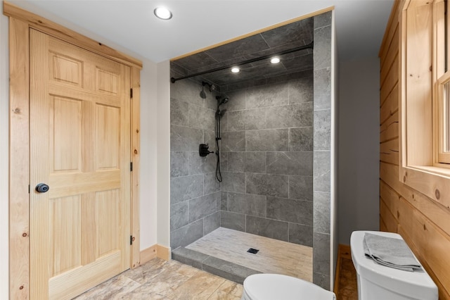 bathroom with tiled shower and toilet