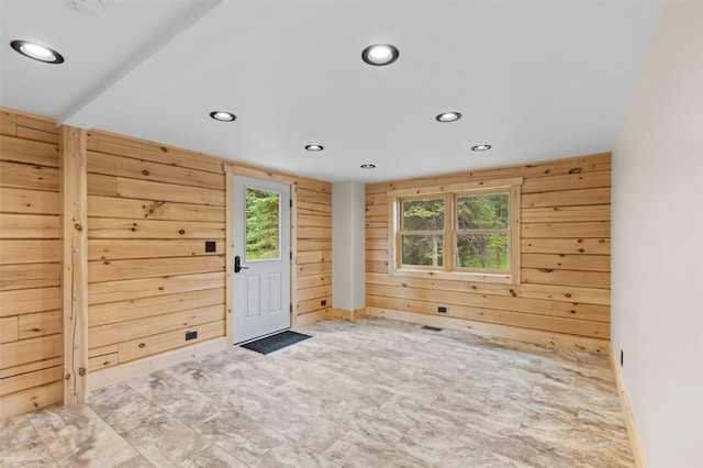 interior space featuring plenty of natural light and wood walls