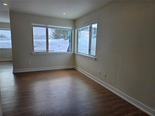 unfurnished room featuring baseboards, dark wood-type flooring, and recessed lighting